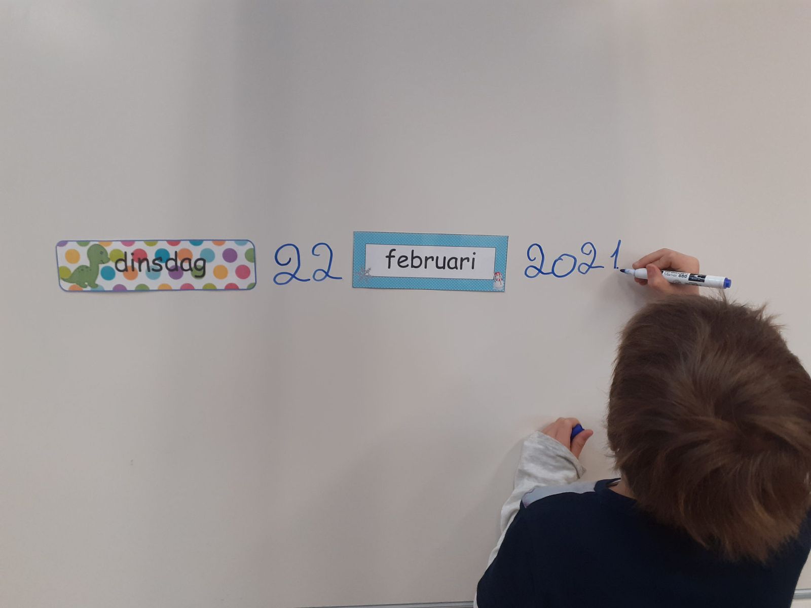 Un élève écrit la date en néerlandais au tableau