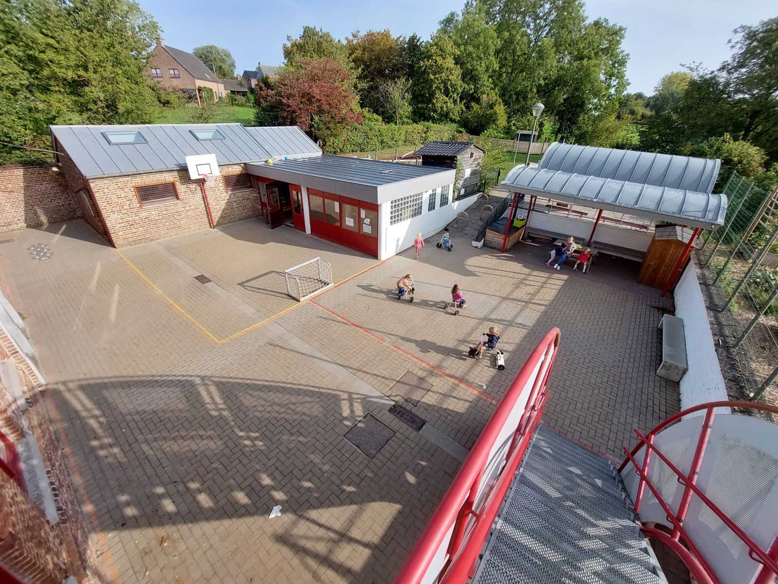 Vue sur le bâtiment et la cour de l'école communale de Lonzée