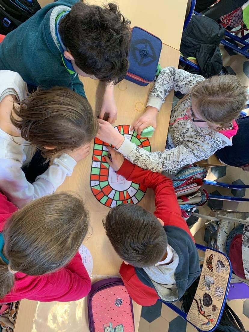 Groupe d'élèves autour d'un jeu de plateau en classe